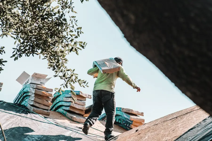 A roofer carrying shingles